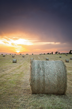 Close view of a hay bale against glowing sunset skies in rural County Galway.